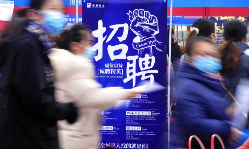 求職者從一家招聘企業(yè)的廣告牌前走過。新華社發(fā)（苑立偉 攝）